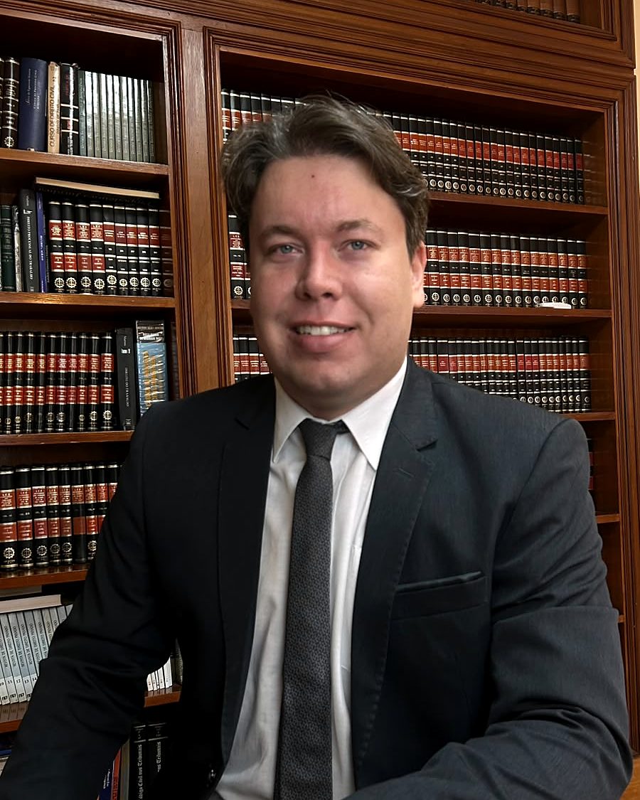 Dr. Lucas Ferreira Faleiros à mesa do escritório